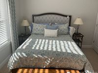 Full front view of assembled queen bed with patterned bedding and pillows