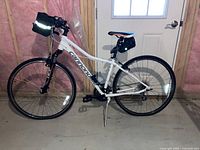 Full side view of white Cannondale bicycle with front and rear bags