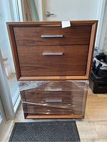 Two bedside tables stacked showing front and side profiles with walnut veneer finish and metal handles.