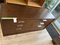 Front and top view of long wooden dresser showing six drawers and medium brown finish