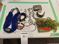 Full lot overview including necklace, cuff bracelet, watch, pouches, and other jewellery