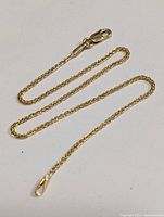 Full view of the 9-inch long 10K gold anklet with lobster clasp lying flat, showing the rope-style chain.