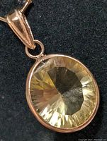 Close-up front view of the oval lemon quartz gemstone set in a 14K gold bezel with a gold bail.