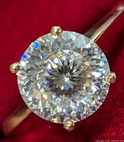 Top view of round brilliant cut moissanite in four-claw yellow gold setting