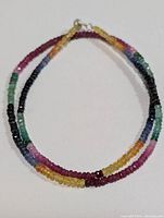 Full view of the multi-color gemstone necklace arranged in a circular form showing the colors and bead arrangement.