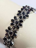 Angled close-up of floral sapphire link clusters