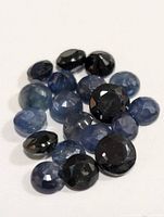 Photo of 19 assorted genuine sapphire gemstones in blue and black colors, various oval and round faceted cuts, total approximate weight 10 carats.