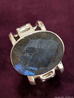 Close-up of the top of the ring showing the oval faceted labradorite stone with blue flashes.