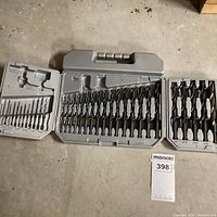 Full view of the open carrying case showing the drill bits arranged in molded compartments with some missing pieces