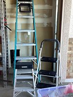 Werner green tall step ladder with metal steps and Husky 2-step aluminum step stool with black platform steps shown side by side indoors.
