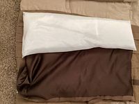 Close-up photo of folded queen comforter with tan light and dark brown blocks, showing fabric texture and colors.