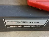 Close-up of label showing 5/8 HP motor, 16,000 cuts per minute, 4-1/8-inch joiner-planer Sears Craftsman branding.