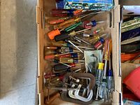 Box with various screwdrivers, multiple C-clamps, and wrenches visible