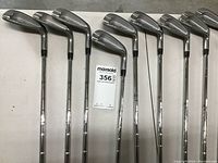 Nine Tommy Armour Silver stainless steel golf irons arranged in a row showing club heads and shafts.