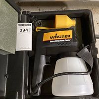 Wagner Heavy Duty Power Painter unit in black plastic carrying case. Unit features black and yellow body with attached white paint container and power cord. Included yellow funnel in the case.