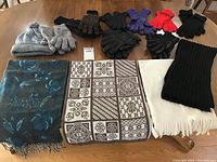 Photo of all scarves, hats, and gloves laid out on table showing pattern, color and condition