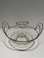 Large glass bowl with integrated brass handles and a small glass dip bowl mounted on a brass holder near the rim.