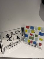 Glass trays displayed on stands, showing a signed Richard Bishop tray with geese and a colorful fused glass tray