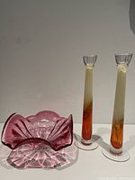 Photo showing the pink ruffled glass bowl next to the pair of tall gradient amber glass candlesticks.