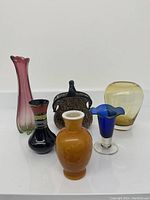 Overview of 6 mixed glass and ceramic vases in various colors and shapes