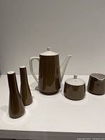 Full set arranged in line: coffee/tea pot, sugar bowl with lid, creamer, salt and pepper shakers.