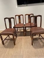 Set of 4 wooden dining chairs arranged in a row showing overall condition and style