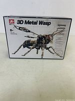 Front and side view of the closed 3D Metal Wasp model kit box showing an image of the assembled mechanic wasp on the box.