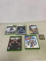 Photo showing Xbox One and Game Boy Color game titles including Star Wars The Old Republic, Middle-earth: Shadow of Mordor, Call of Duty Black Ops III, and Pokemon Yellow cartridge.