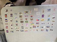 Top view of many colorful postage stamps arranged loosely on a table showing diverse subjects such as flowers, birds, and historic sites.