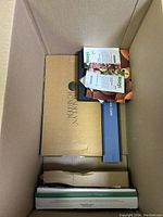 Top-down view of large box with Garden Carter box, extension cable, and bird food packets.