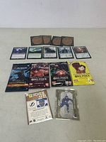 Photo showing Magic cards laid out with card backs and front illustrations, along with 5 booster packs including One Piece and Magic: The Gathering Remastered Draft