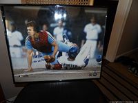 Framed photo showing Bob Boone in red catcher gear and a baserunner sliding, signed and inscribed by Boone.