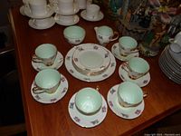 Full display of the dinnerware set including 8 cups, 8 saucers, dessert plates on wood table