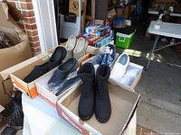 Shows all 6 pairs of shoes in their boxes, including black boots, slip-on clogs, and slip-on shoes in various colors