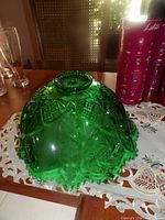 Top view of the green glass bowl showing intricate pressed star and diamond patterns and the scalloped edge.