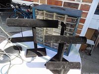Blue plastic storage box with multiple clear drawers containing jewelry-making supplies, two black velvet display stands in front, setup on table outdoors.