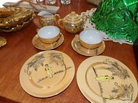 Image showing the full tea set with cups, saucers, plates, teapot, sugar bowl, and creamer, all painted with Oriental figures and foliage
