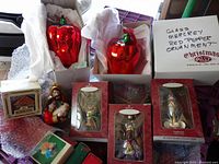 Full display of lot includes mercury glass red pepper ornaments, Holy Family and Wise Men figurine ornaments boxed, and a Santa's workshop snow globe.
