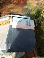 Coastal grommet curtain panels in soft blue with label showing 2 per pack and size 54 in x 84 in