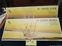 Two wooden model ship kits in original packaging for the Santa Maria and Cutty Sark ships with visible text and illustrations