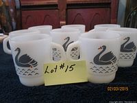 Set of eight white milk glass coffee mugs with black swan designs and handles.