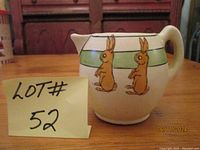 Photo of the antique Roseville Juvenile creamer showing round body, green band, and two bunnies.