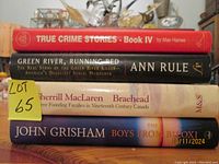 Photo of the book spines showing titles and authors including Max Haines, Ann Rule, Sherrill MacLaren, and John Grisham.