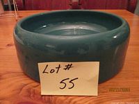 Front and side view of large teal glazed stoneware pet bowl on wooden surface showing thick rim and size.