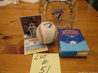 Photo showing 1991 All-Star full baseball card pack with one opened fold-out and 1985 Blue Jays ashtray along with signed baseball and player card