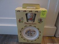 Original box containing Bunnykins child's plate and cup, showing front with decorative bunny borders and window to cup