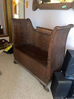 Left-front overall view showing scrolled side panel, hinged seat and claw feet