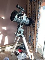 Full setup showing telescope tube on equatorial mount and aluminum tripod