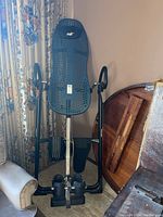 Full view of Teeter Hang Ups Gravity Machine inversion table, showing black mesh backrest, frame, and foot holding mechanism.