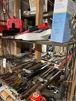 Shelf with assorted hammers, hatchet, measuring tapes, and box of electric de-icing cable